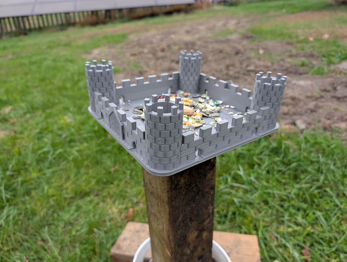 Side view of grey PETG castle bird feeder mounted on a wooden post