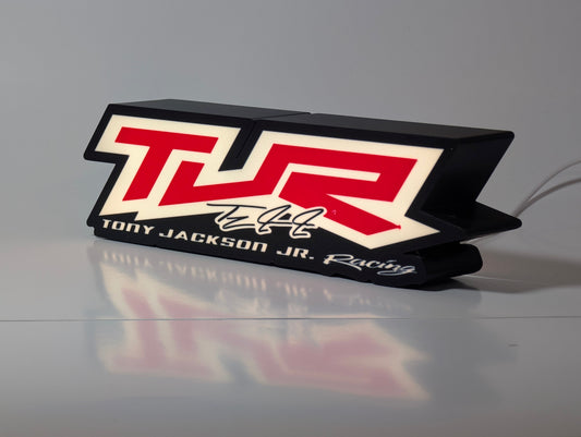 Illuminated red & white racing logo in a black light-box housing
