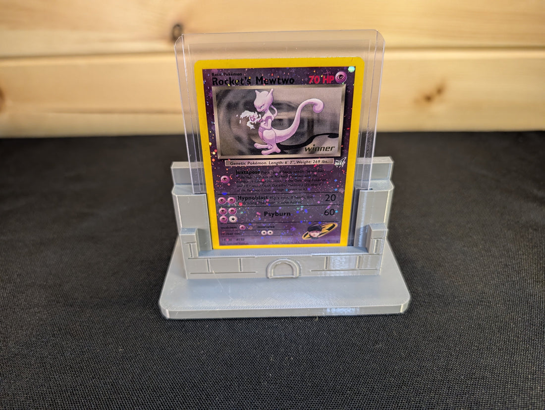 Grey compact castle stand displaying a trading card in a clear toploader