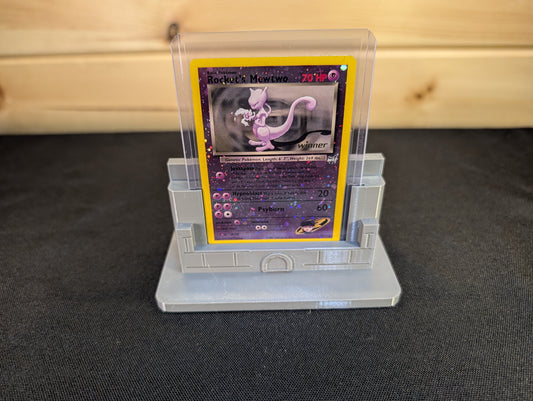 Grey compact castle stand displaying a trading card in a clear toploader