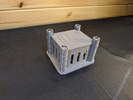 Grey square castle dice jail with its lid fitted between four corner towers