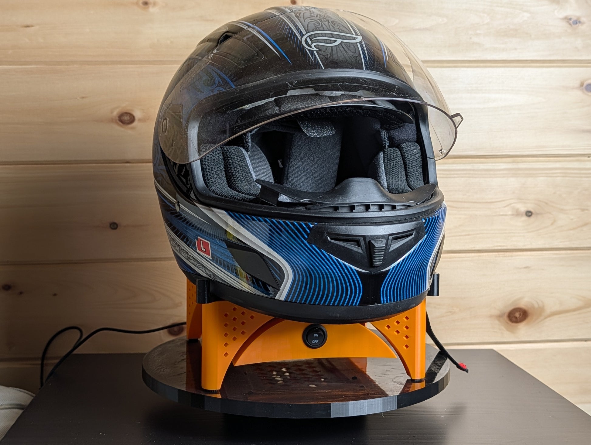 Orange Trackside AirFlow helmet stand holding a motorcycle helmet