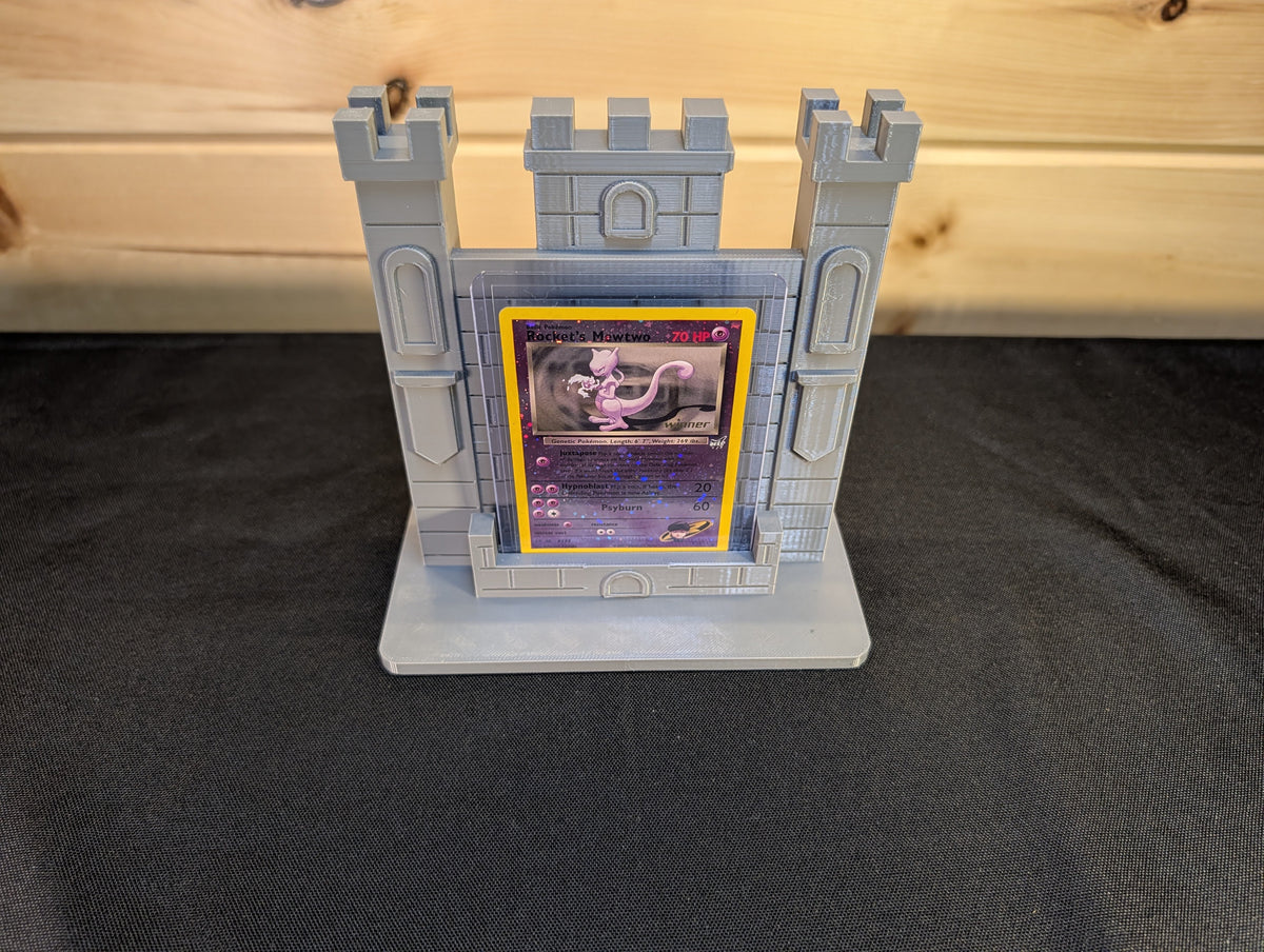 Actual castle tower stand displaying a trading card in its protective holder; card and holder not included