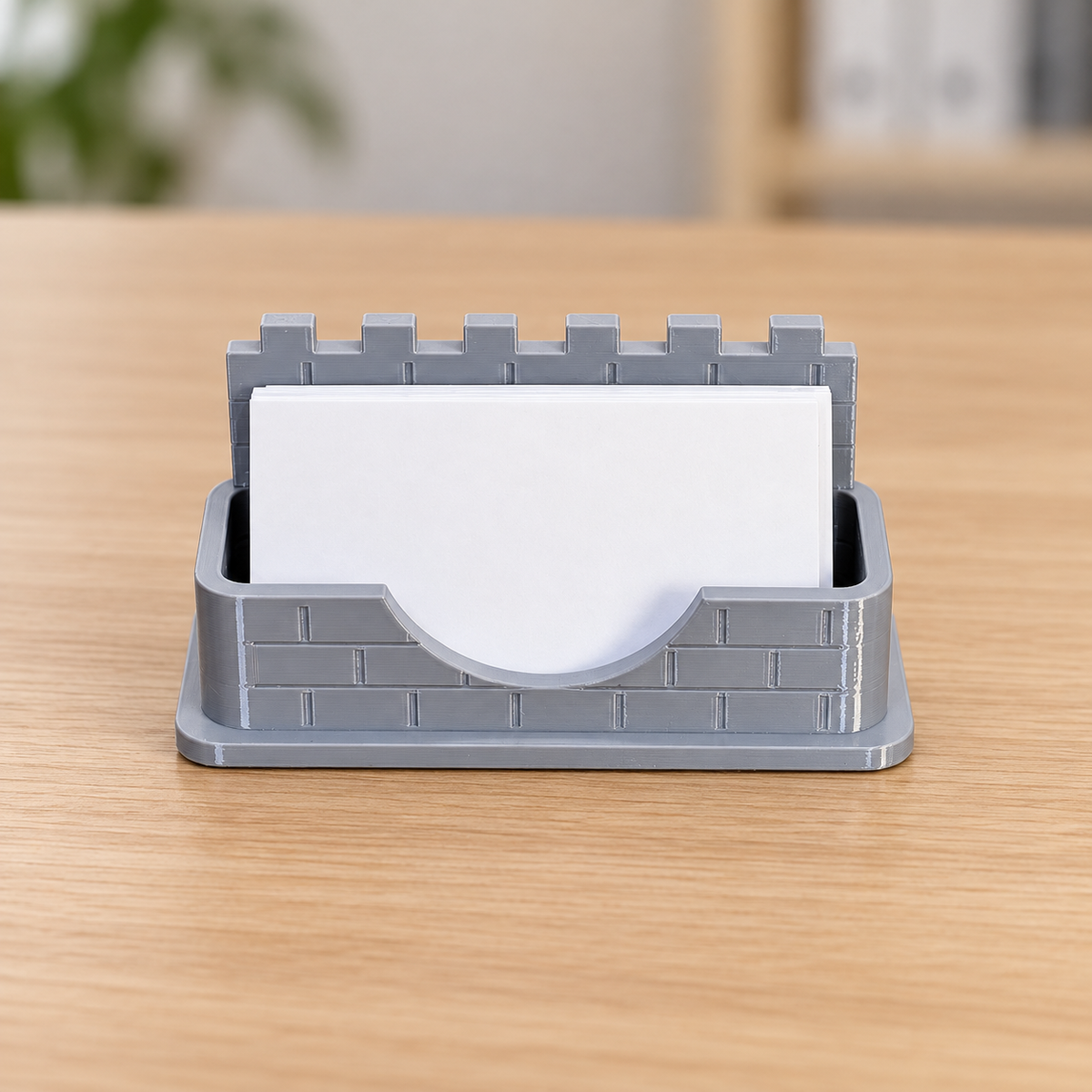 Grey PETG castle wall business card holder with blank cards; retouched office background