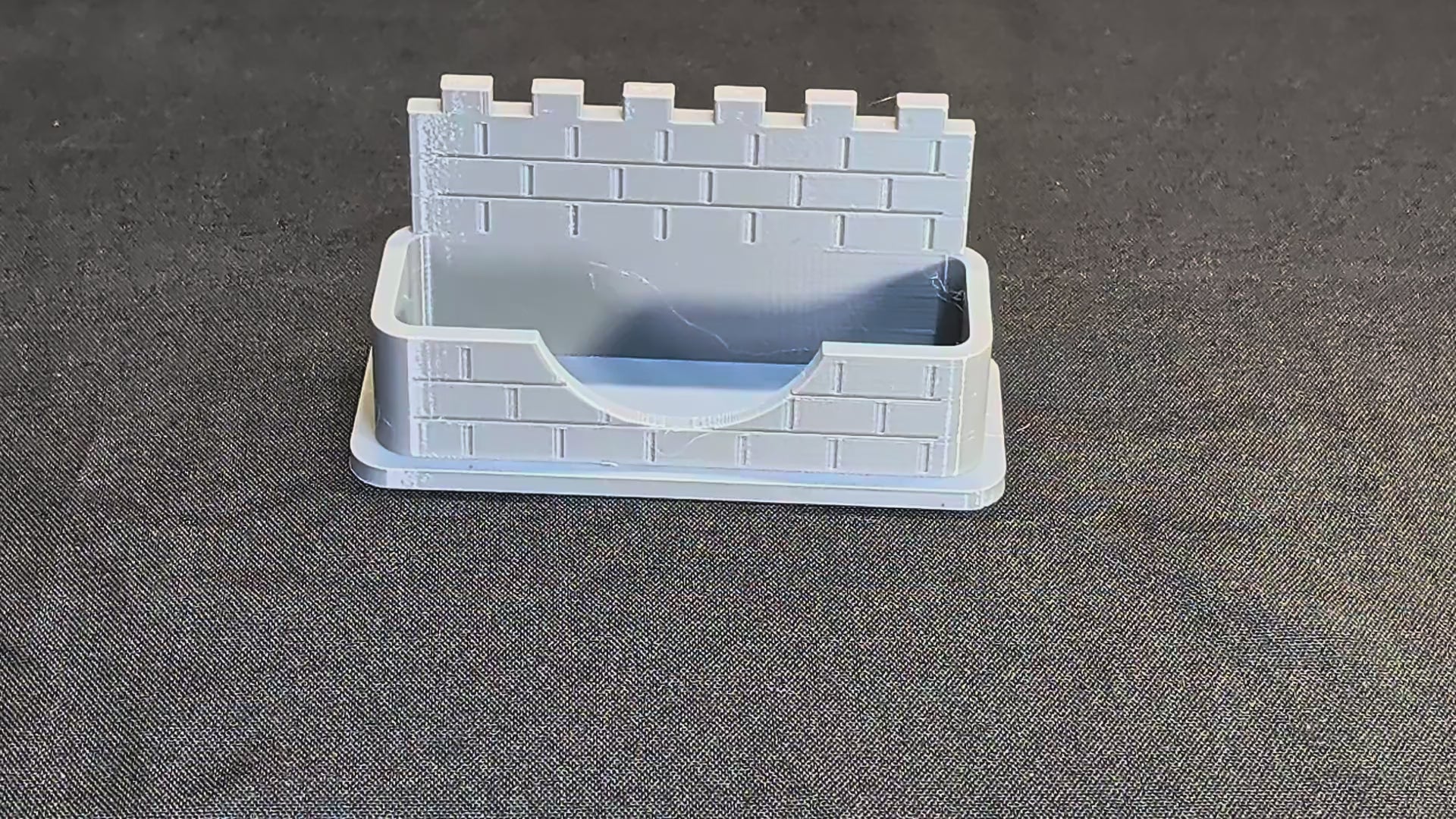Castle wall business card holder demonstration with a card placed into the pocket